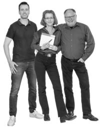 Drei Personen stehen nebeneinander, die mittlere hält einen Notizblock und einen Stift, alle tragen legere Kleidung.